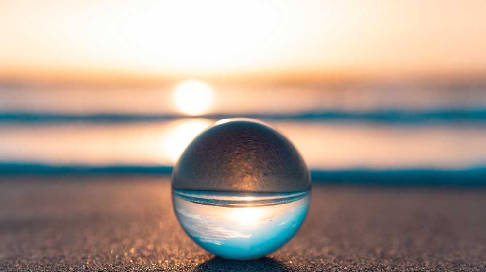 image of a clear sphere ball with the sun setting behind it