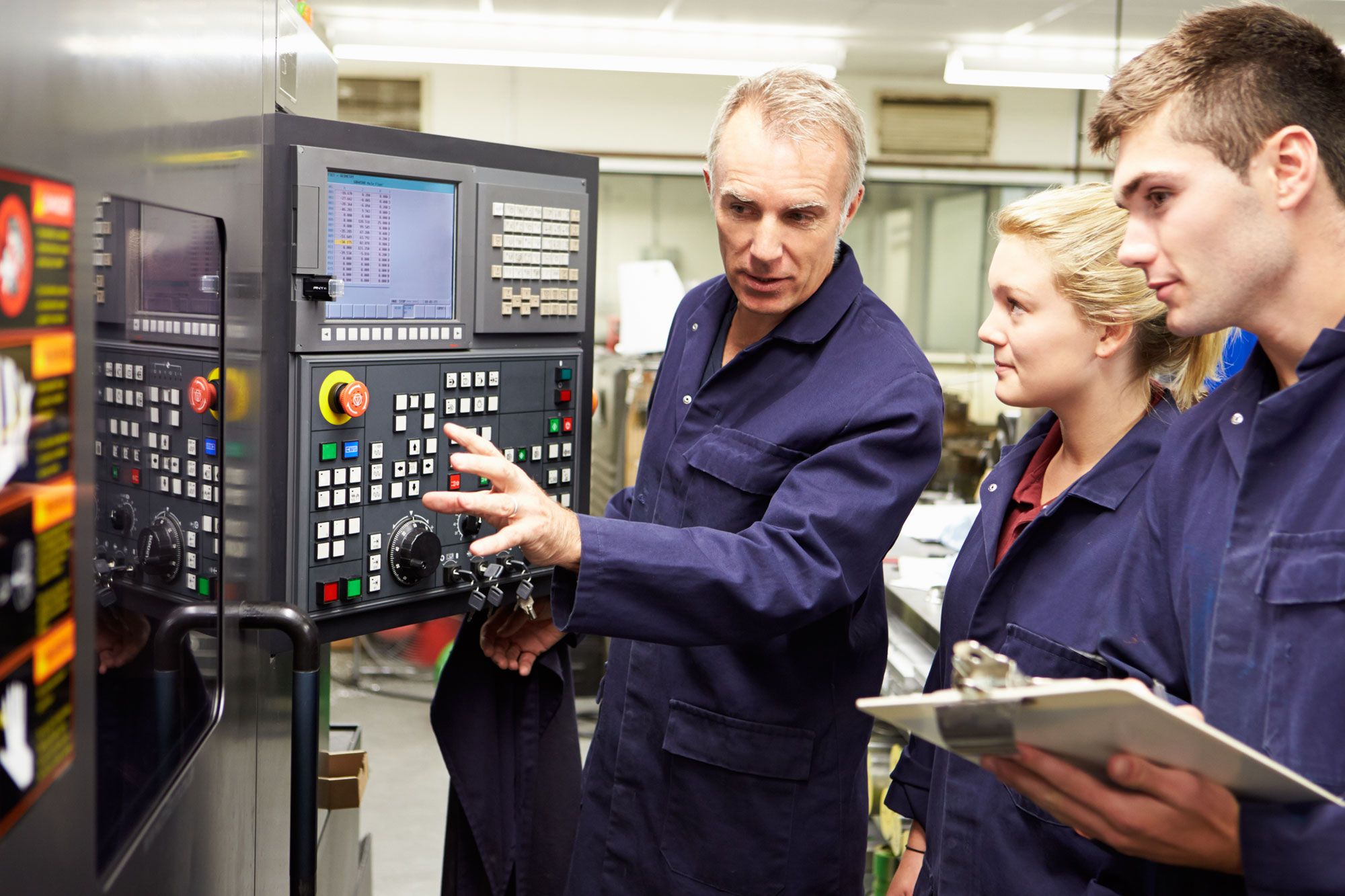 Two young people going through an engineering apprenticeship assessment with a more senior teacher.