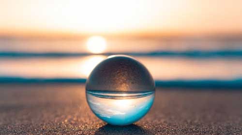 image of a clear sphere ball with the sun setting behind it