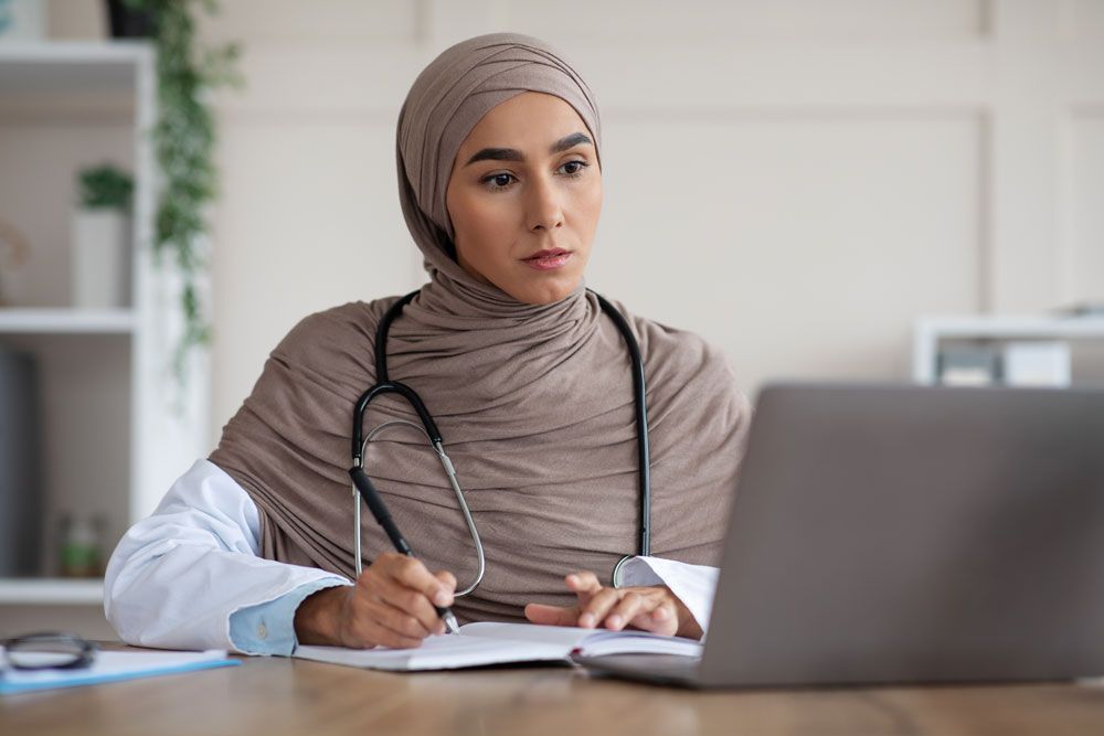 Female Doctor having online assessment on laptop