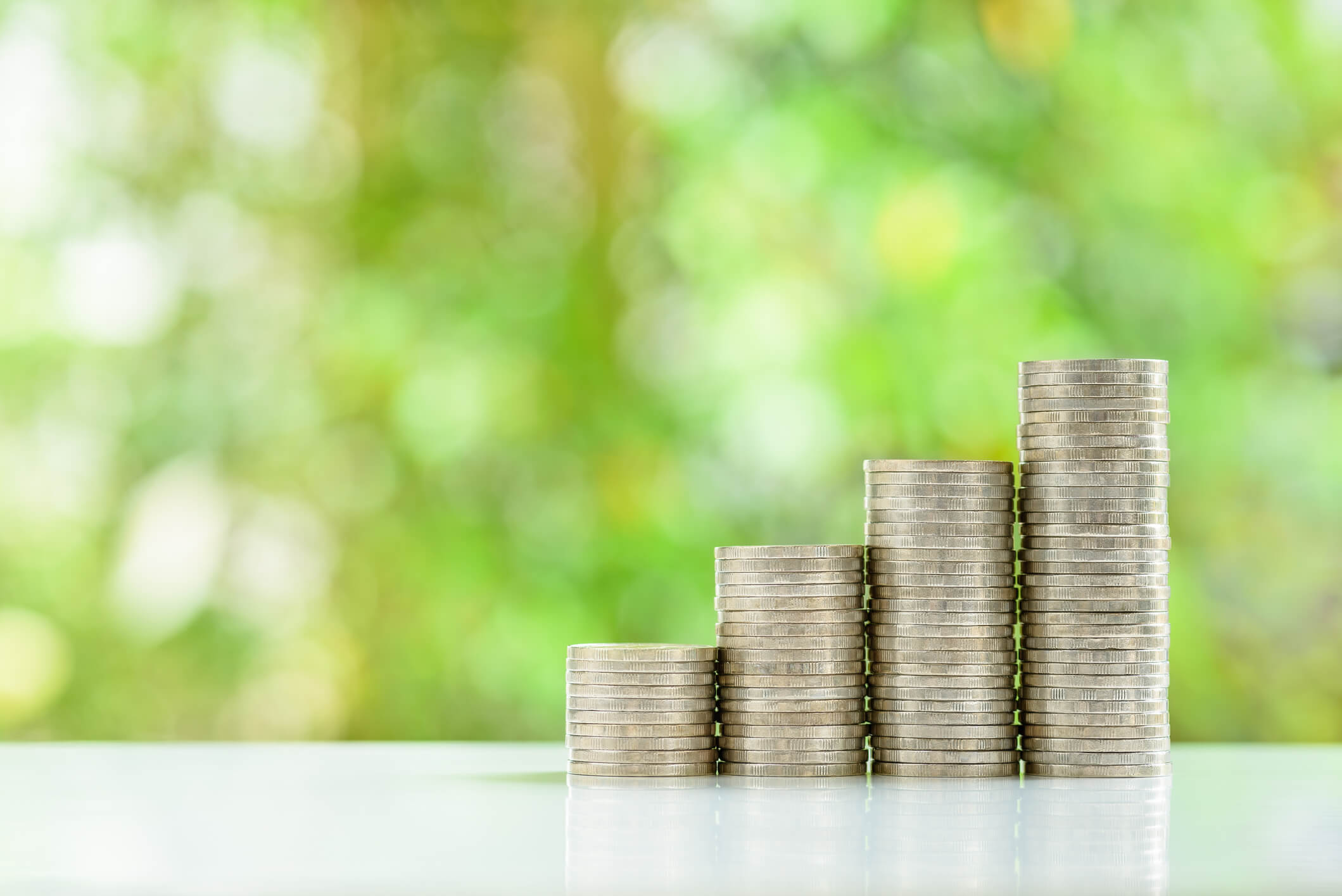 Money stacking up on a table to illustrate the work of the Pensions Management Institute, who use TestReach for online examination delivery.