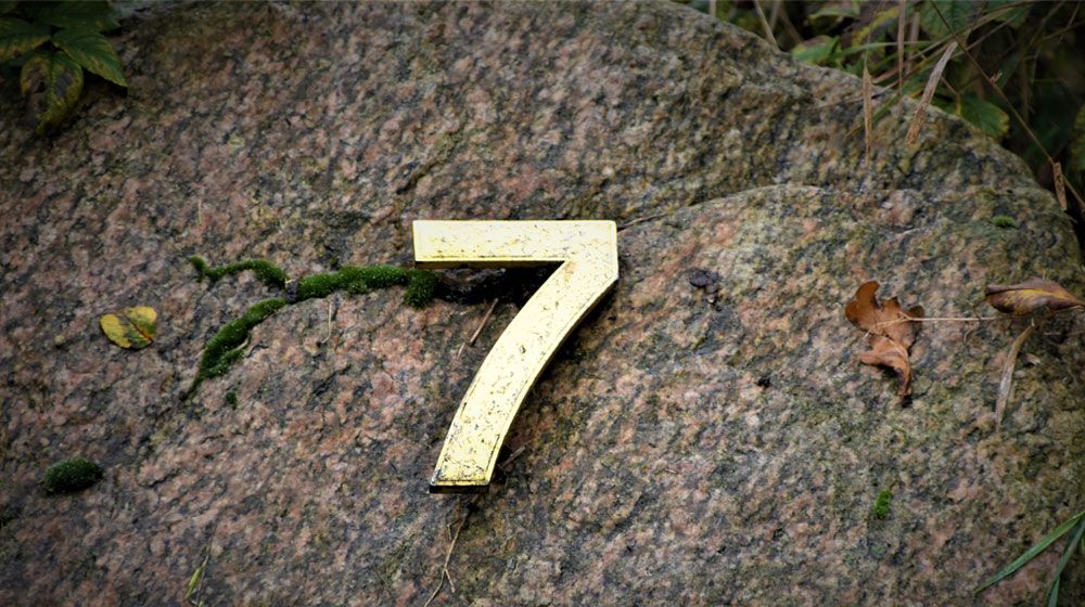 The number 7 on a stone representing 7 facts about Online Exams