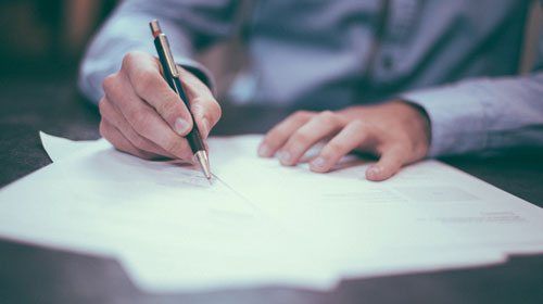 Man writing on paper doing an exam